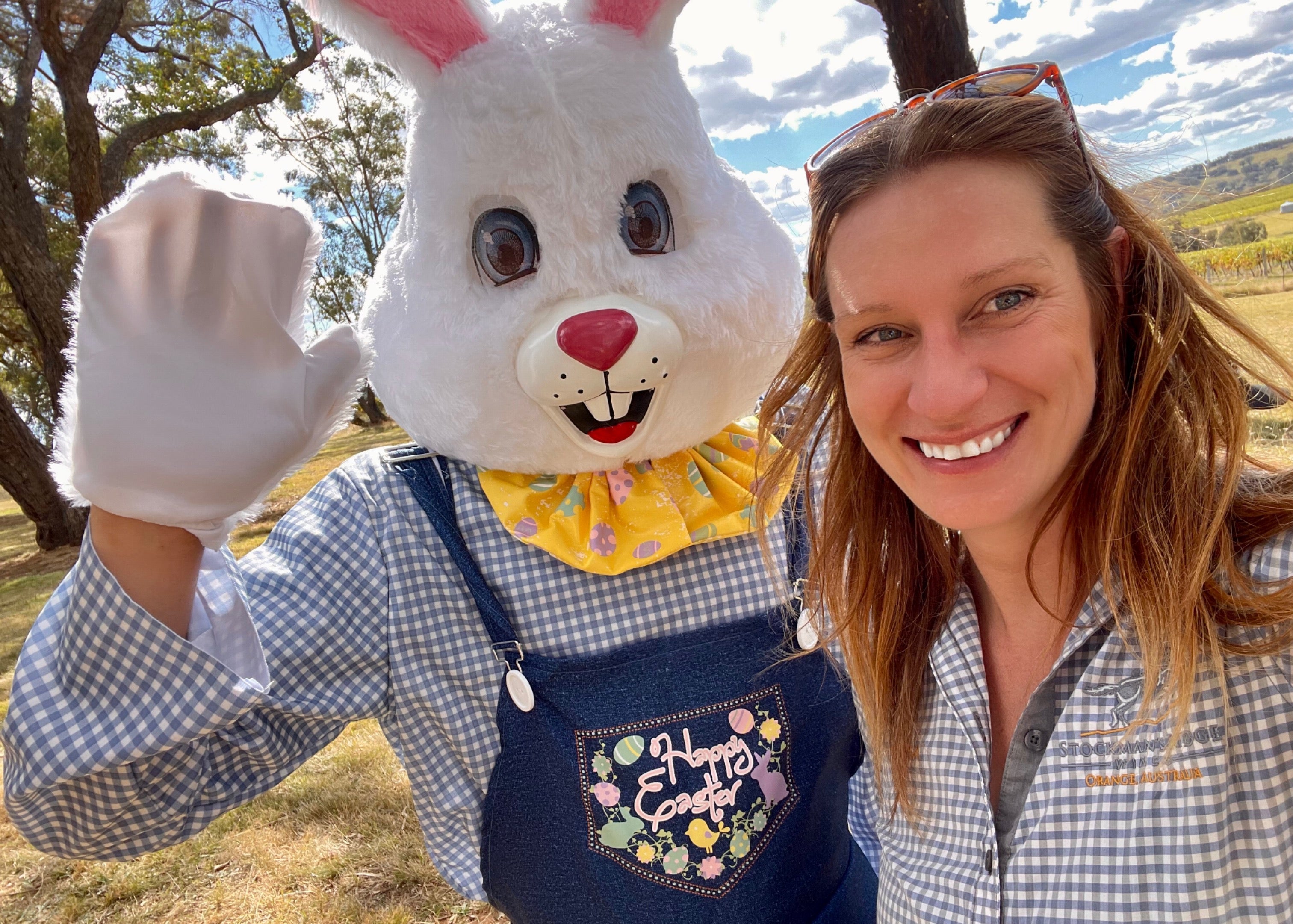 Person in a bunny costume with a woman outdoors on a sunny day