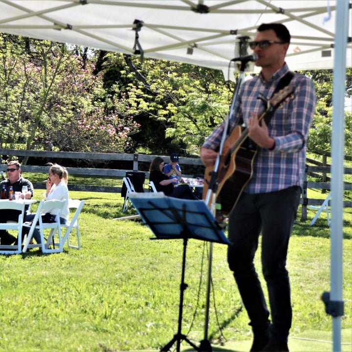 Man singing with guitar outside t Stockmans Ridge Wines