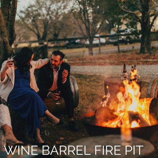 A man and woman drinking wine while sitting around a fire at Stockman's Ridge Wines